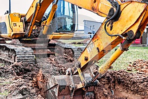 Close up of excavator bucket at construction site. The excavator is digging a trench for underground utilities. Construction