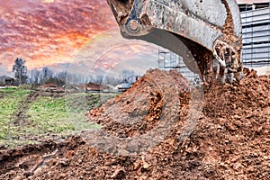 Close up of excavator bucket at construction site. The excavator is digging a trench for underground utilities. Construction