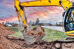 Close up of excavator bucket at construction site. The excavator is digging a trench for underground utilities. Construction