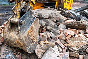 Close-up of excavator bucket loading rocks, stones, earth