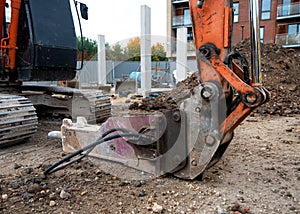 Close up of excavator bucket placed on the ground in safe position