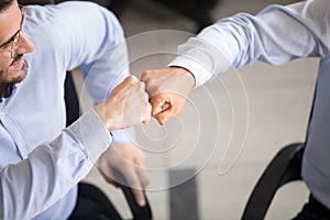 Close up of excited business partners give fist bump