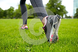 Close up of exercising woman legs on grass in park