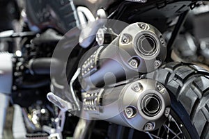 Close-up of exhaust or Intake of black sport racing Motorcycle with new tire and wheel in showroom. Low Angle Photograph Of