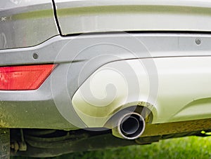 Close-up of exhaust pipe of classic crossover car with plastic parts