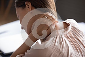 Close up exhausted woman touching massaging tensed neck muscles