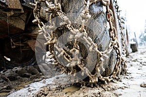 Close-up for extreme big off road 4x4 vehicle wheel with a snow and mud chains.. Extreme off-road 4x4 vehicle with snow and mud