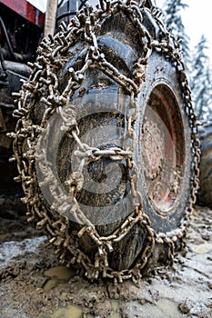 Close-up for extreme big off road 4x4 vehicle wheel with a snow and mud chains.. Extreme off-road 4x4 vehicle with snow and mud