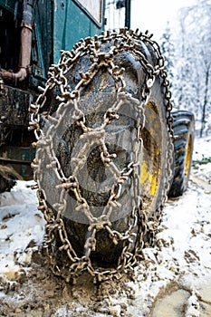 Close-up for extreme big off road 4x4 vehicle wheel with a snow and mud chains.. Extreme off-road 4x4 vehicle with snow and mud