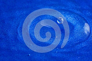 Close up, extreme macro. High speed photography. Drop of water. A splash of water droplets on the surface creates circular waves