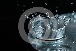 Close up, extreme macro. High speed photography. A drop of water when it strikes the surface of the disk forms a crown.