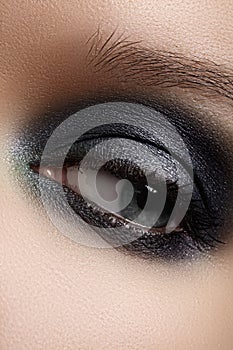 Close-up eye with gray make-up and silver glitter