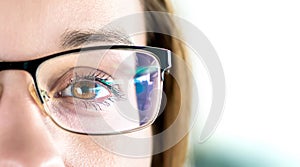 Close up of eye and woman wearing glasses. Optometry, myopia or laser surgery concept. Brown eyed girl with spectacles.