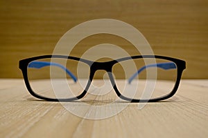 Close up of eyeglasses on brown wooden background