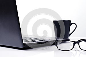 Close up of eyeglasses with labtop computer and coffee cups on white backgrounds