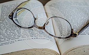 Close up of eyeglasses on top of an open book