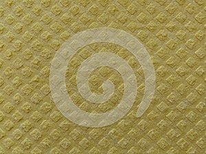 Close-up of fabric with embossed convex print. Bulging diamonds on yellow microfiber or dishwashing sponge. Background and free