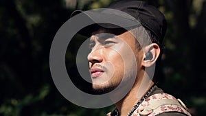 close up of the face of an Asian man enjoying the view of the mountains in the middle of a forest