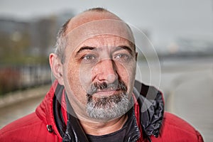 Close-up face of a bearded balding man over 50