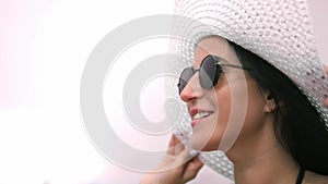 Close-up face of beautiful fashion smiling woman tourist wearing trendy sunglasses and hat relaxing