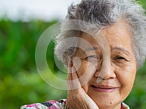 Close-up face of a beautiful smiling senior woman and looking at the camera. Concept of aged people and healthcare