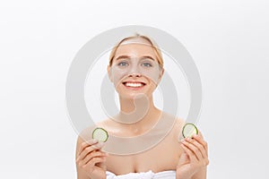 Close-up face of beautiful woman with clean fresh healthy skin and with cucumber slices. Isolated on white.