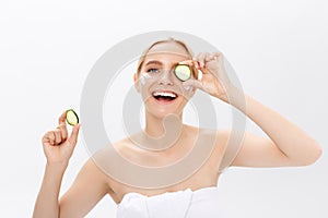 Close-up face of beautiful woman with clean fresh healthy skin and with cucumber slices. Isolated on white.