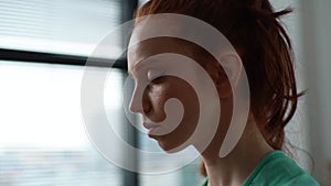 Close-up face of calm young woman meditating with closed eyes and doing deep breathing yoga practices on background of