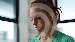 Close-up face of calm young woman meditating with closed eyes and doing deep breathing yoga practices on background of