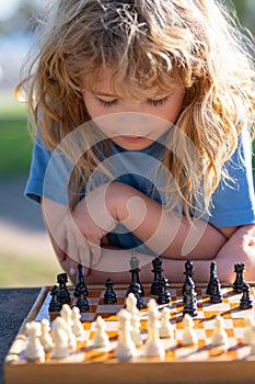 Close up face of clever smart child. Chess strategy. Kid playing chess. Chess, success and winning.