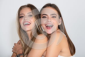 Close up face of cute happy smiling models. Fashion portrait two girls with natural makeup. Two sensual elegant women