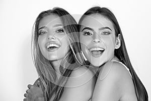 Close up face of cute happy smiling models. Fashion portrait two girls with natural makeup. Two sensual elegant women