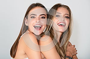 Close up face of cute happy smiling models. Fashion portrait two girls with natural makeup. Two sensual elegant women