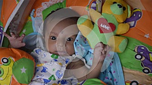 Close up face of cute newborn baby boy in playing on bed. One month old Sweet infant toddler Closeup portrait. Indian ethnicity.