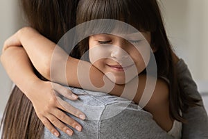 Close up face of daughter cuddle her mother heartfelt moment photo