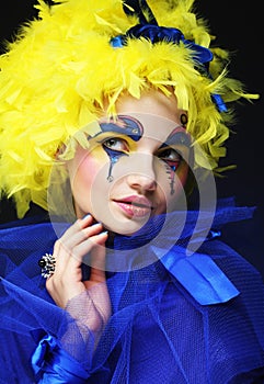 Close up of a face of a girl with creative visage and yellow wig.