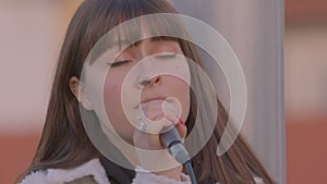 Close-up of the face of a girl singing into a microphone. The female singer.