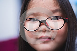 Close-up of the face of a girl wearing glasses to help her see from nearsightedness
