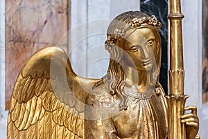 Close-up on face of golden female angel sculpture
