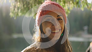 close up face of happy joyful woman hiker at beautiful mountain lake with turquoise water enjoys amazing calm autumn