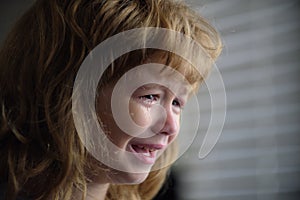 Close up face of little boy crying with tears. Portrait of a kid Cry at home. Child sad Emotions.