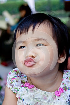 Close up face of lovely and cute asian baby making funny mouth