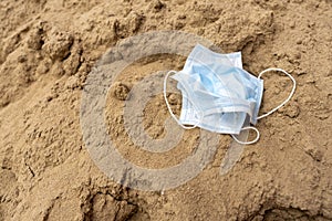 Close up of face mask waste disposal on the ground.