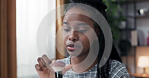 Close-up of face ofv woman with dark skin of African American descent, the makeup artist is talking to a friend to whom