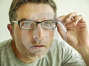 Close up face portrait of attractive man checking vision trying glasses at optometrist . guy 40s during optical examination