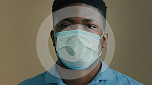 Close up face portrait sick african man ethnic male patient businessman wearing medical mask respirator cover mouth nose