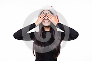 Close up face portrait of smiling woman with hands closed eyes wearing winter santa hat close eyes and waiting for gift on white b
