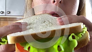 Close up face portrait of woman eating sandwich.