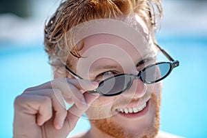 Close-up face of red-haired smiling man in sunglasses