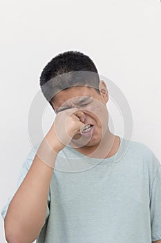 Close up face of teenage guy, hands on the nose, smelly stinky face expression